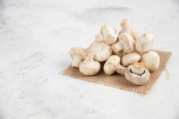 White mushrooms isolated on a piece of burlap.