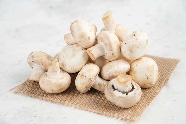 White mushrooms isolated on a piece of burlap.