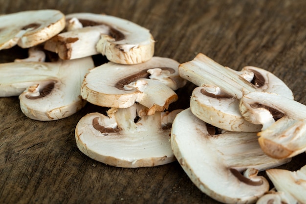 White mushrooms sliced on brown wooden desk