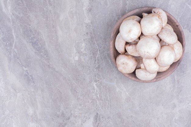 White mushrooms in a wooden cup.