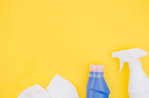 White napkin; spray bottle and detergent blue bottle with copy space for writing the text on yellow backdrop