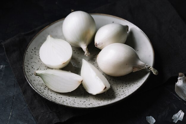 White onions on a plate with black background