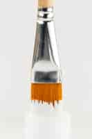 Free photo white paint bottle and dipped brush