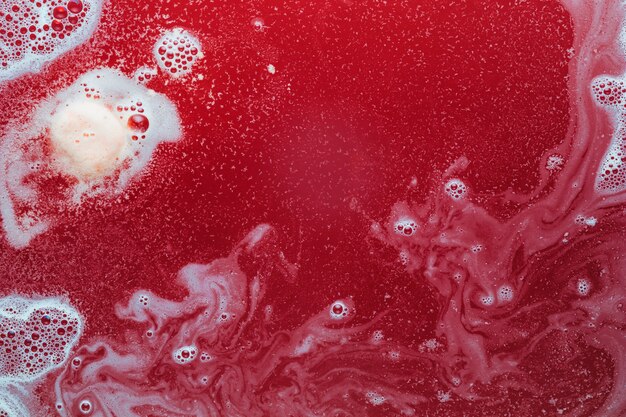 White paint and bubbles on red water