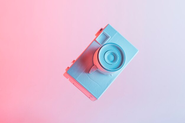 White painted camera against pink background