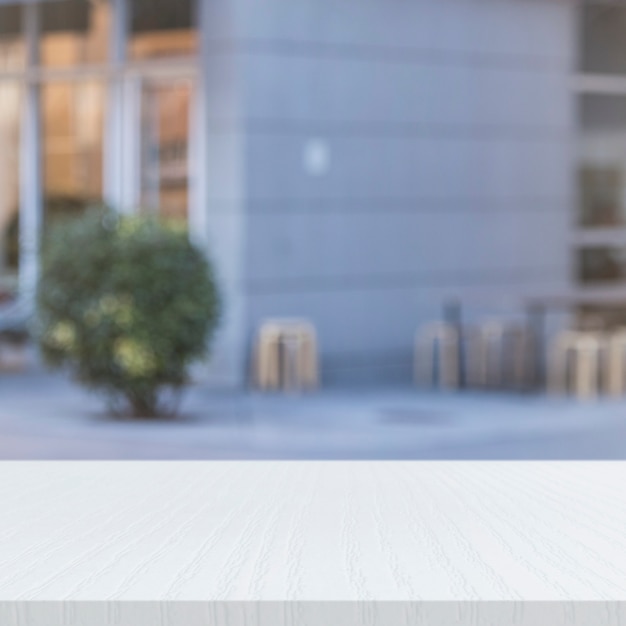 White painted wooden table in front of office building