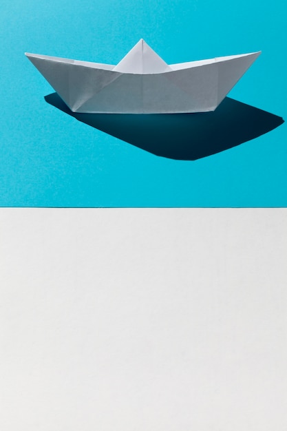 White paper boat on blue background