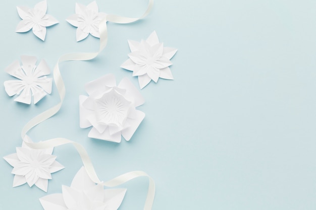 Free photo white paper flowers on table with copy-space