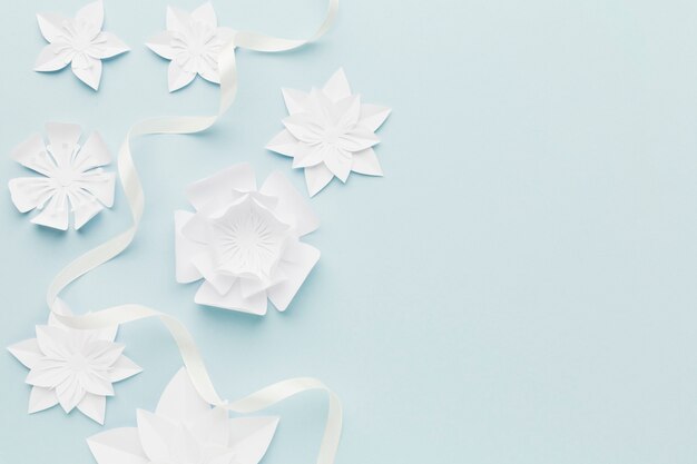 White paper flowers on table with copy-space