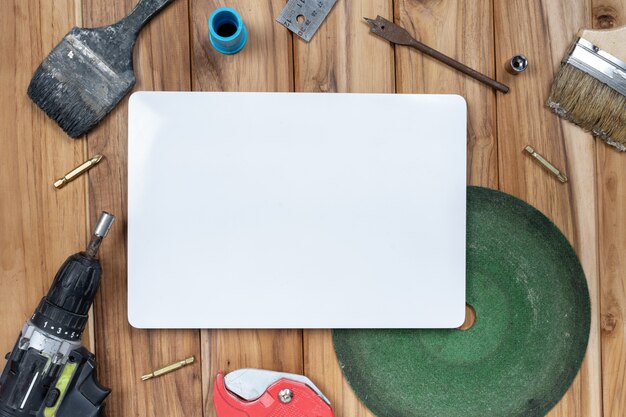 White paper and manual tool set on wooden floor.