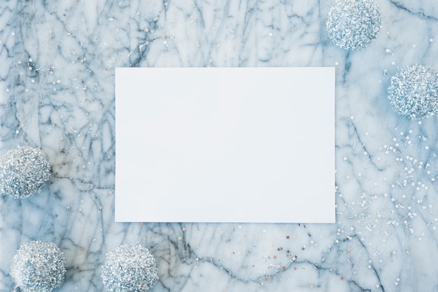 Белая бумага между орнаментальными снежками и конфетти
