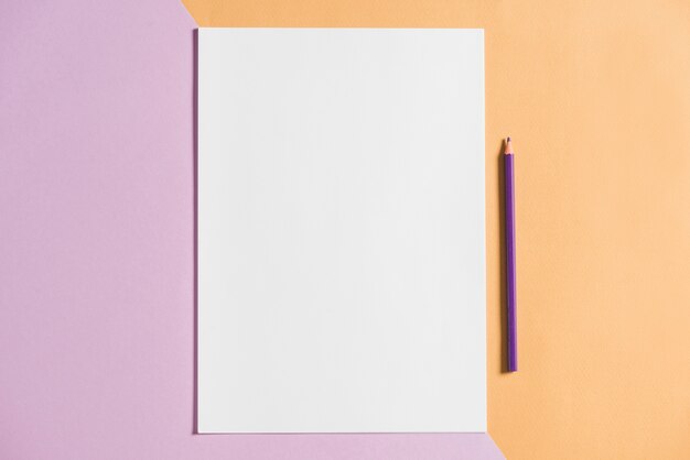 White paper with pencil on colored background