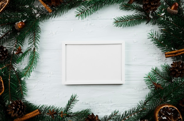 Free photo white photo frame between fir branches