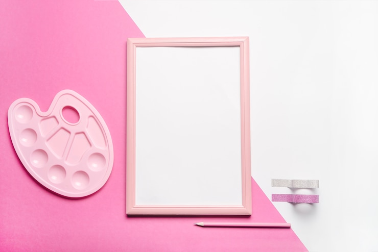 Free Photo white picture frame with ribbons; pencil and palette on dual background