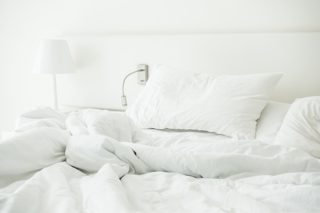 Белая подушка на мятой кровати
