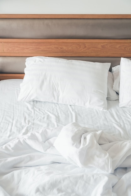 White pillow with rumpled bed