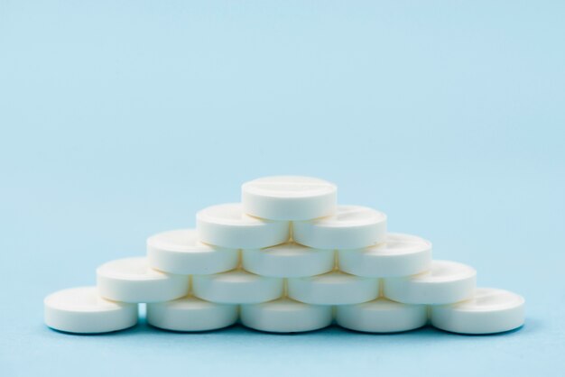 White pills arrangement on blue background