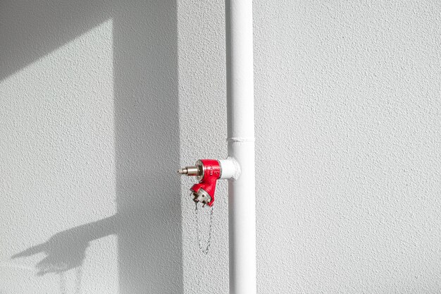 White pipe with red fire extinguisher