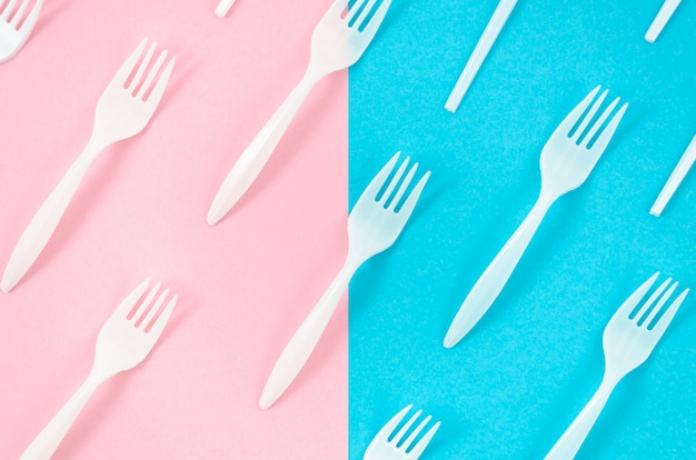 White plastic forks on colorful background