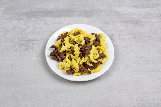 White plate of corn flakes placed on table