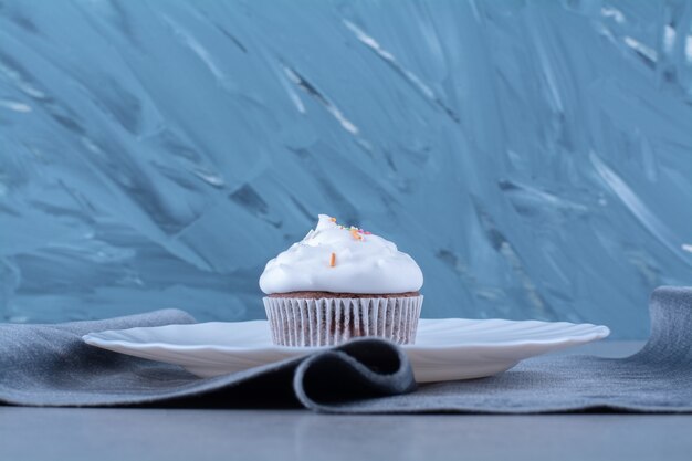 カラフルなふりかけのクリーミーなカップケーキの白いプレート。