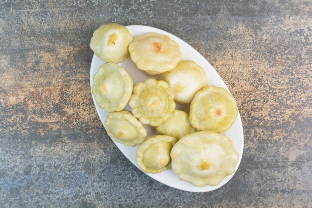 A white plate of delicious fruits on marble background. High quality photo