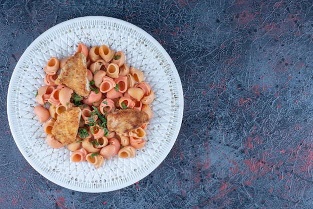 Foto gratuita un piatto bianco di deliziosi maccheroni e carne di pollo.