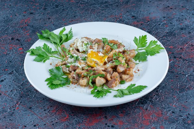 A white plate of fried egg with herbs .