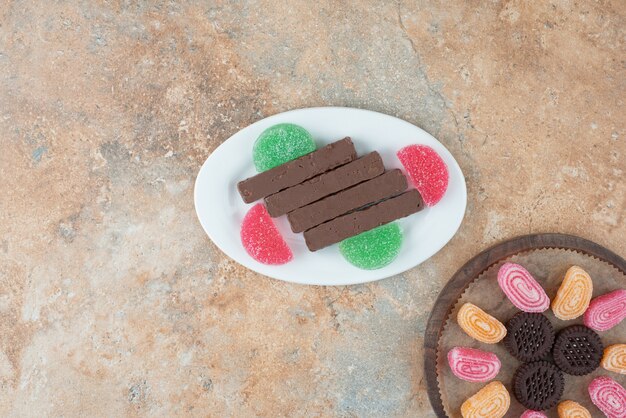 A white plate full of cookies and marmalade on marble background