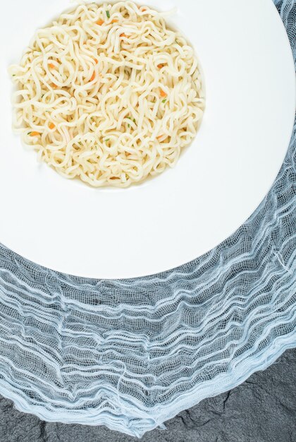 A white plate full of delicious noodles pasta. 