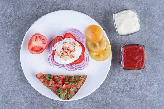 A white plate full of sliced vegetables and boiled egg. High quality photo