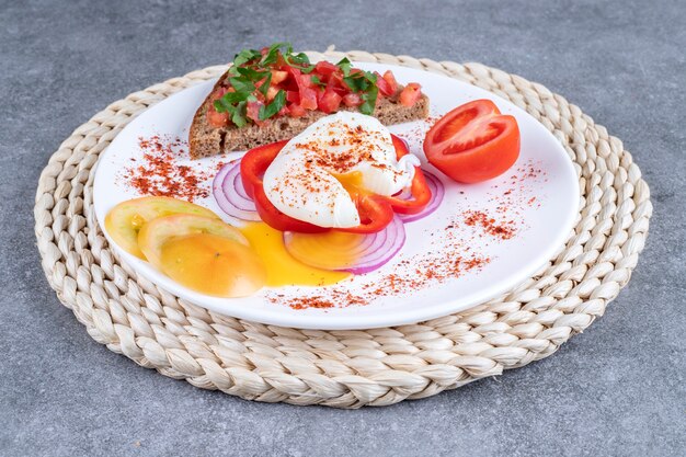 A white plate full of sliced vegetables and boiled egg. High quality photo