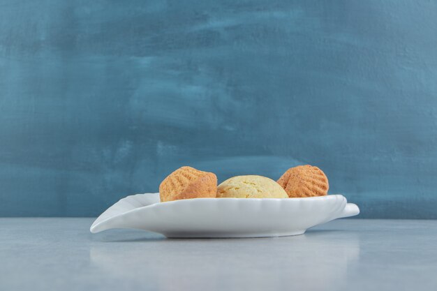 A white plate full of sweet delicious cookies with sugar.  