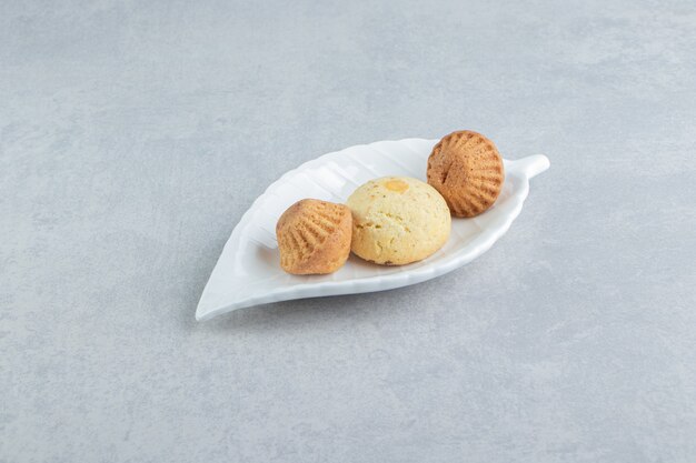 A white plate full of sweet delicious cookies with sugar.  