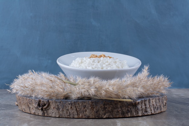 A white plate of healthy oatmeal porridge on a wooden piece . 