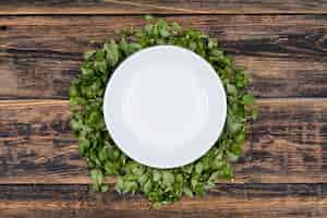 Foto gratuita piatto bianco su foglie