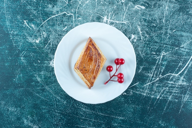 A white plate of sweet delicious pastry on a blue background. High quality photo