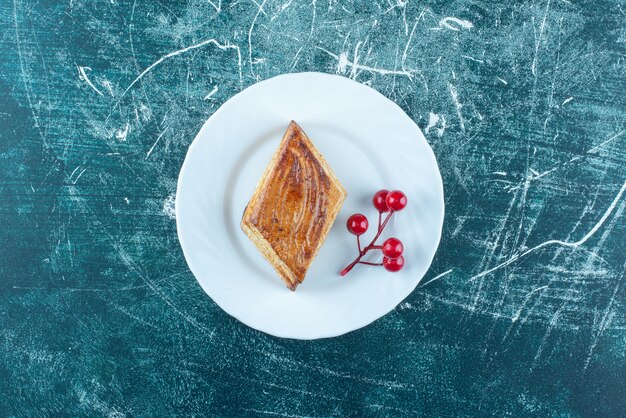 A white plate of sweet delicious pastry on a blue background. High quality photo