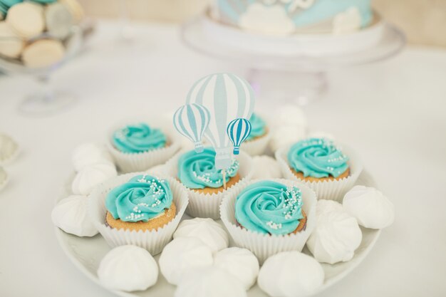 White plate with blue cupcakes and kisses