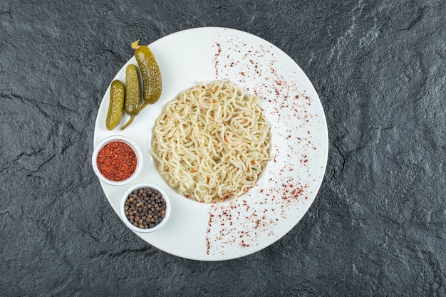 맛있는 국수와 작은 오이 절인 흰 접시.