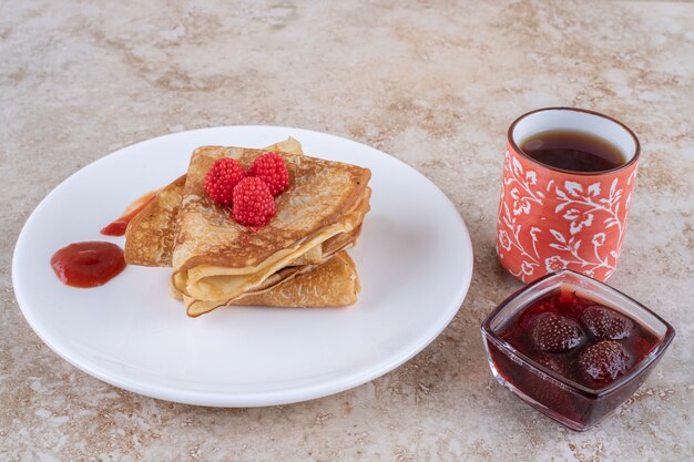 A white plate with pancakes and berries 