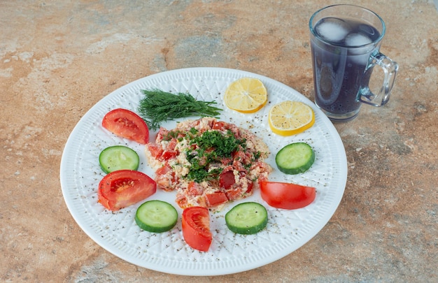 Foto gratuita un piatto bianco con verdure e una tazza di succo.