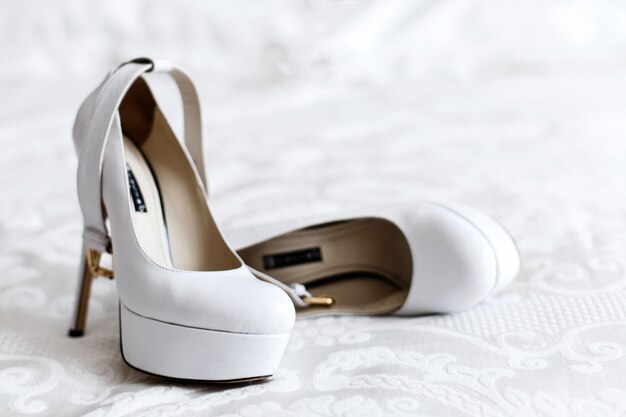 White platform shoes lie on the bed 