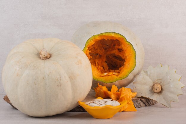 White pumpkin and pumpkin seeds on white.