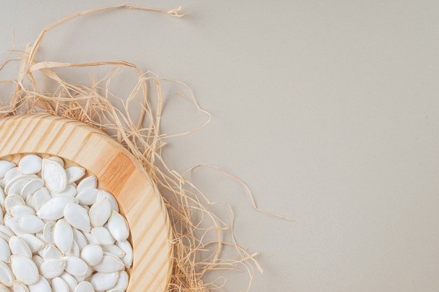 White pumpkin seeds in a wooden platter.