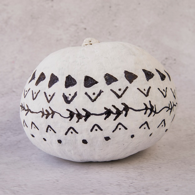 Free photo white pumpkin with black patterns