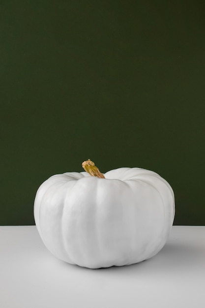 White pumpkin with green background still life