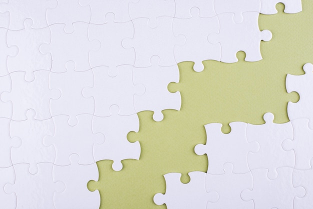 Free photo white puzzle pieces and green background