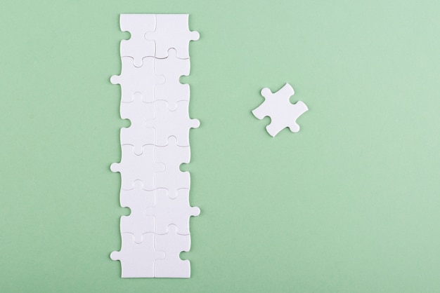 Free photo white puzzle pieces with green background