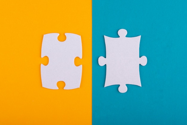 Free photo white puzzle pieces with orange and blue background